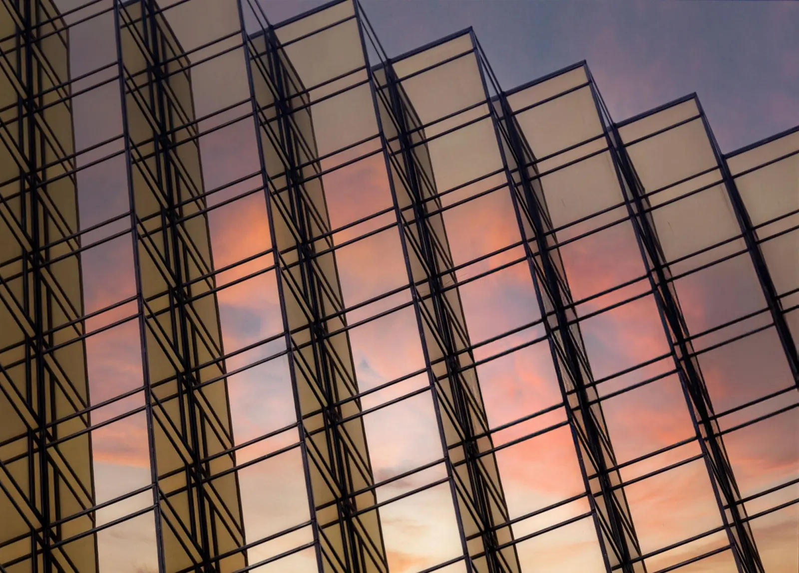 Glass building facade reflecting the evening sky